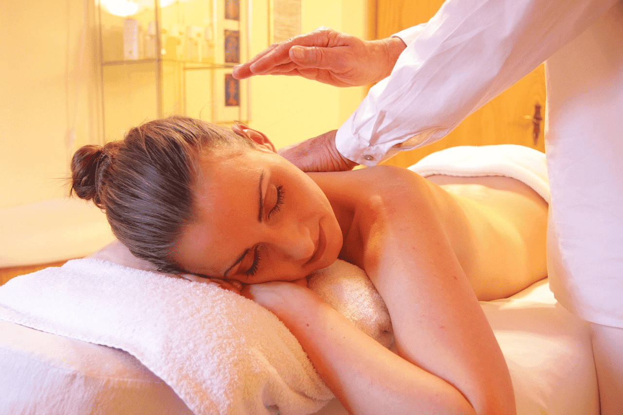 Person receiving a relaxing back massage in a serene spa setting.